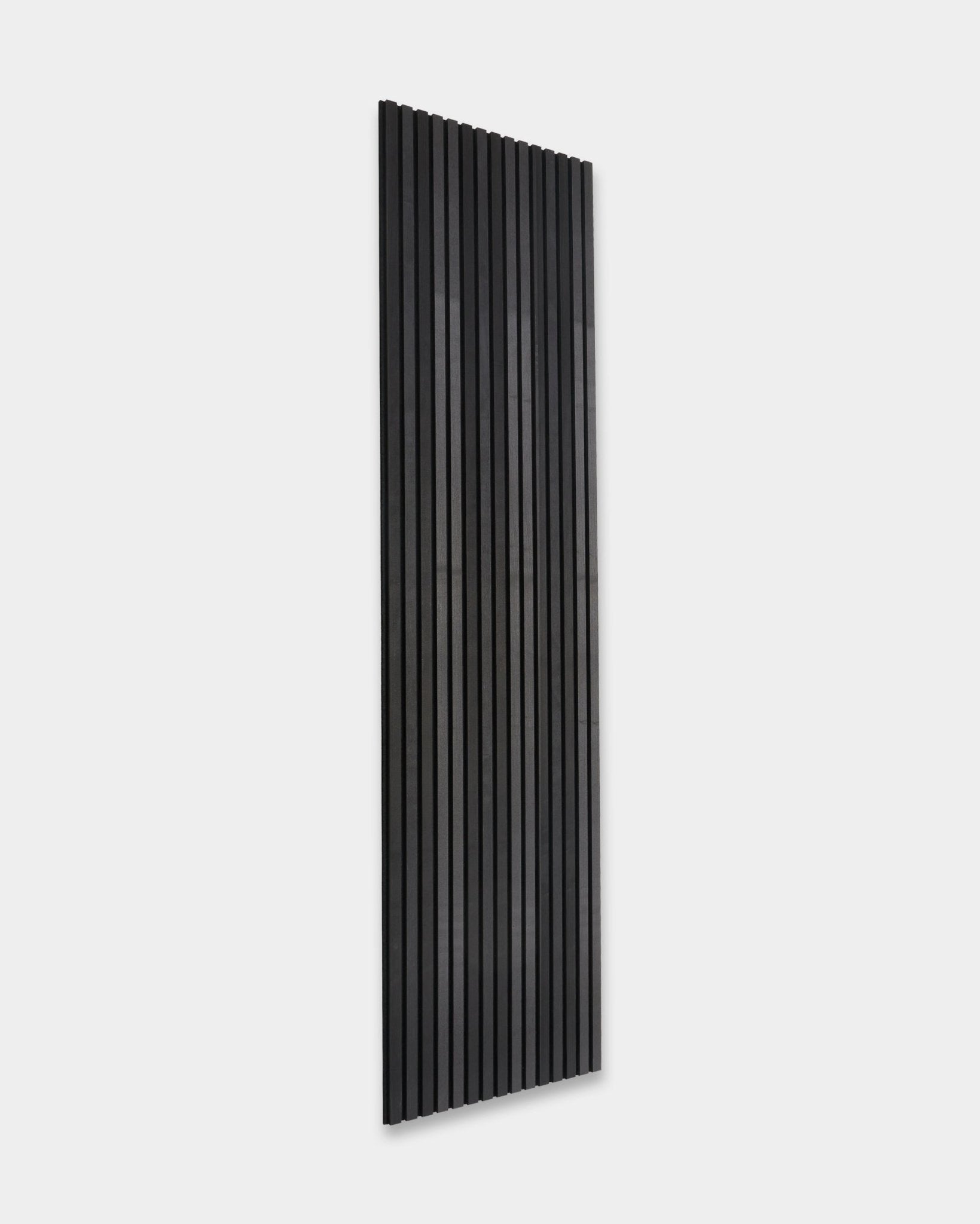 WoodUpp Akupanel Tonal acoustic panel in Black Ash (300x60cm) with vertical slats installed on a plain light gray wall, showcasing minimalist Scandinavian design.