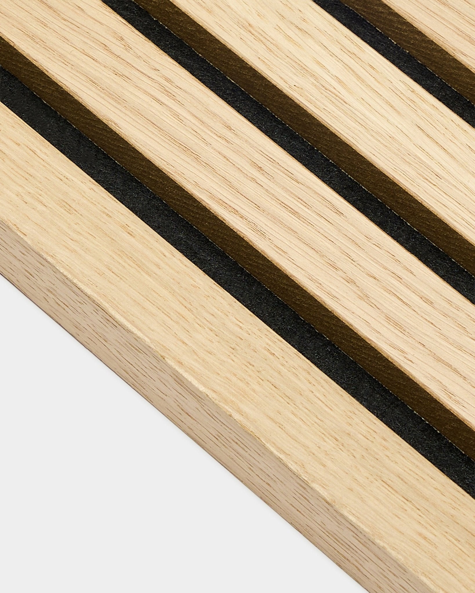 Close-up of WoodUpp Akupanel Classic Oak End Lamella, 2.2 cm thick, displaying parallel black and brown stripes characteristic of Nordic acoustic panels.