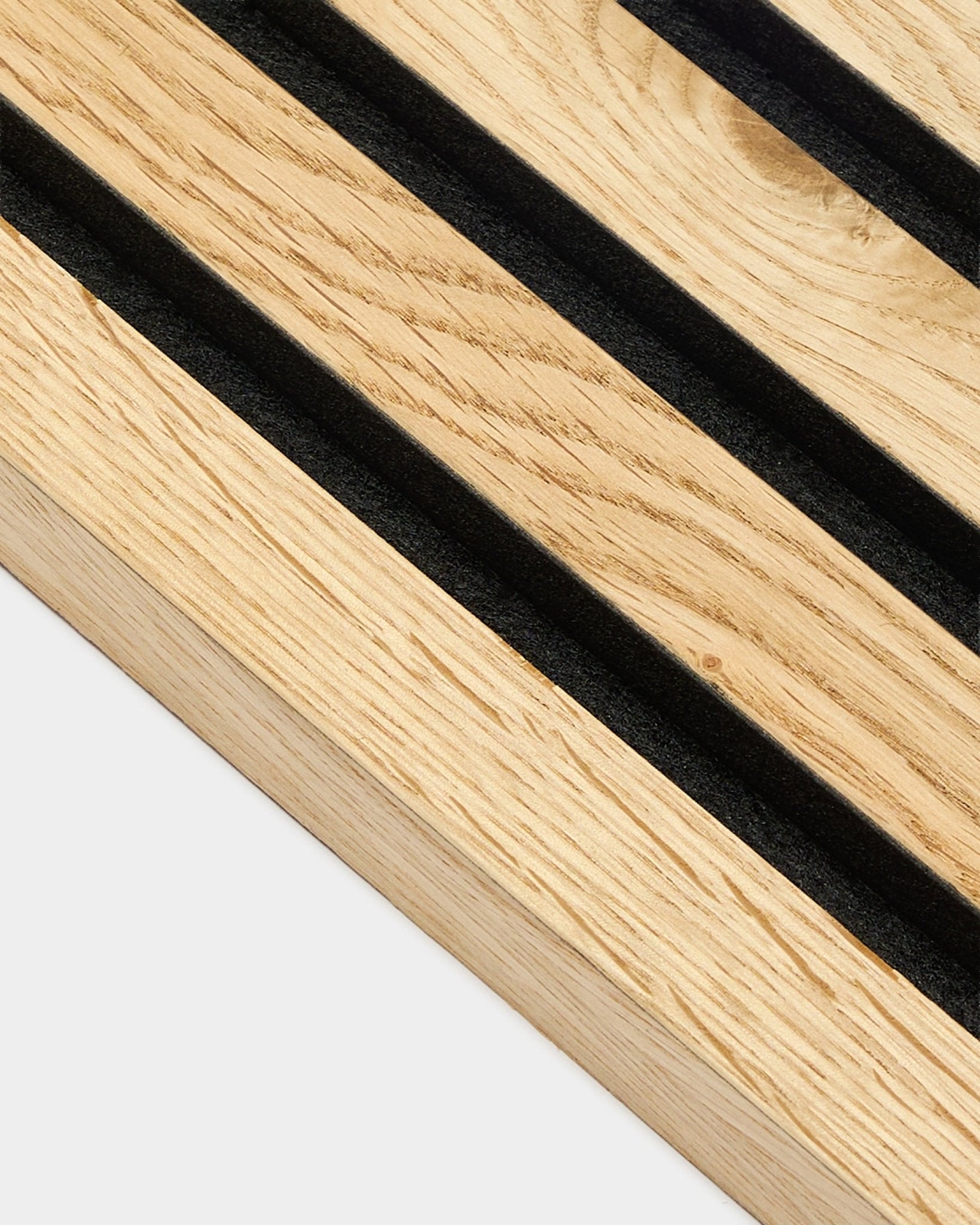 Close-up of WoodUpp Akupanel end lamella in rustic natural oak, 2.2 cm thick, with diagonal black grooves and visible natural wood grain texture.