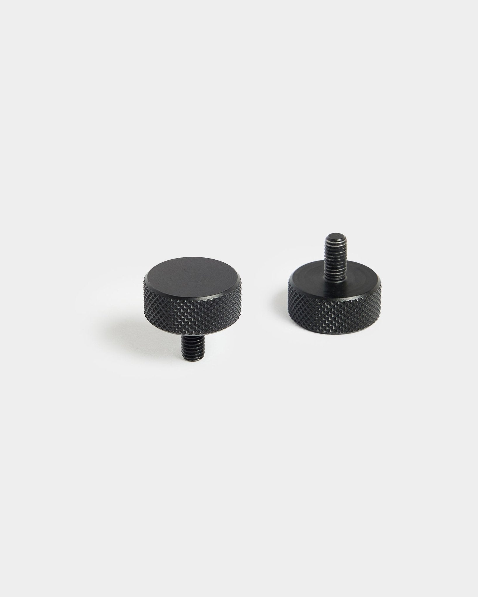 Pair of black WoodUpp Finger Screws (M5x10 mm, 20x8.8) with knurled edges, designed for use with acoustic panel accessories, on plain white background.