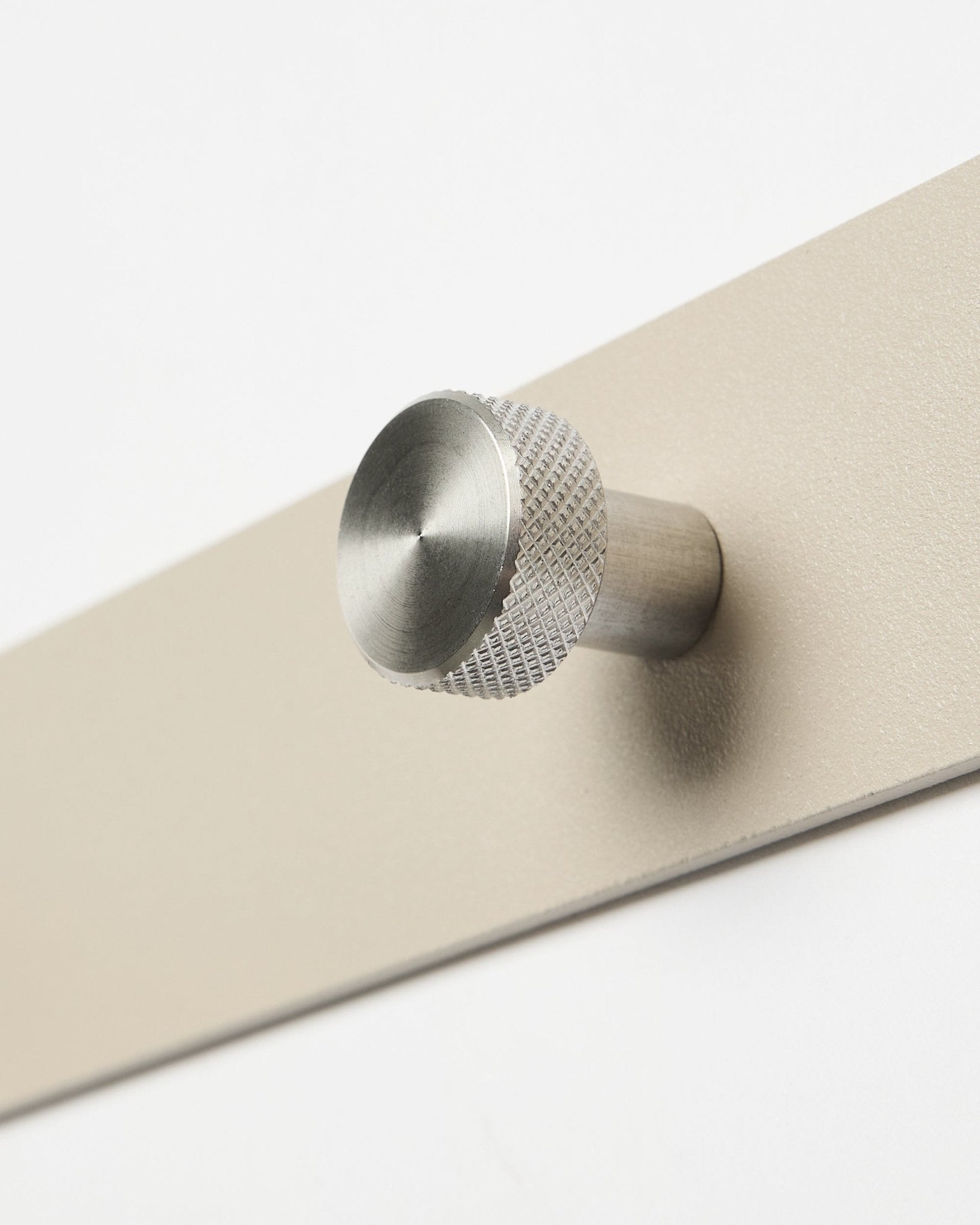 Close-up of WoodUpp Norr Coat Hook Rack in beige and stainless steel, X7, designed as an accessory for Akupanel acoustic wood panels or hallway organization.